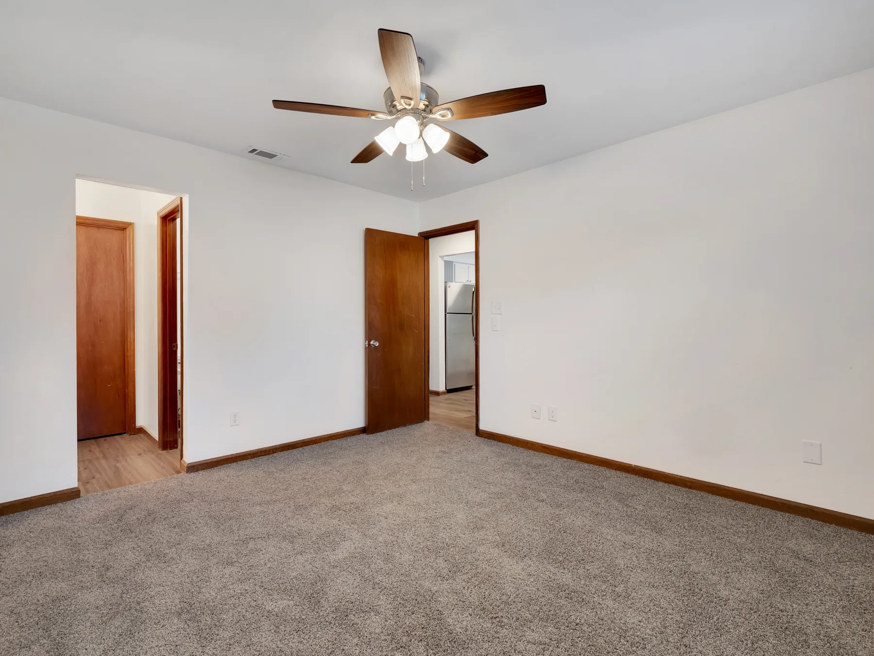 Bedroom with ceiling fan, walk-in closet and en-suite bath at Castle Apartments