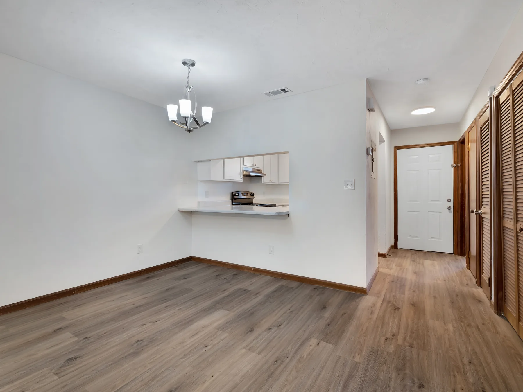 Dining area with chandelier and breakfast bar pass-through to the kitchen at Castle Apartments