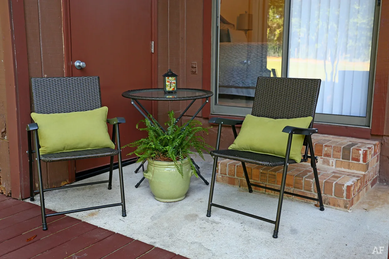 Private patio with two chairs and a small table outside a Castle Apartments home